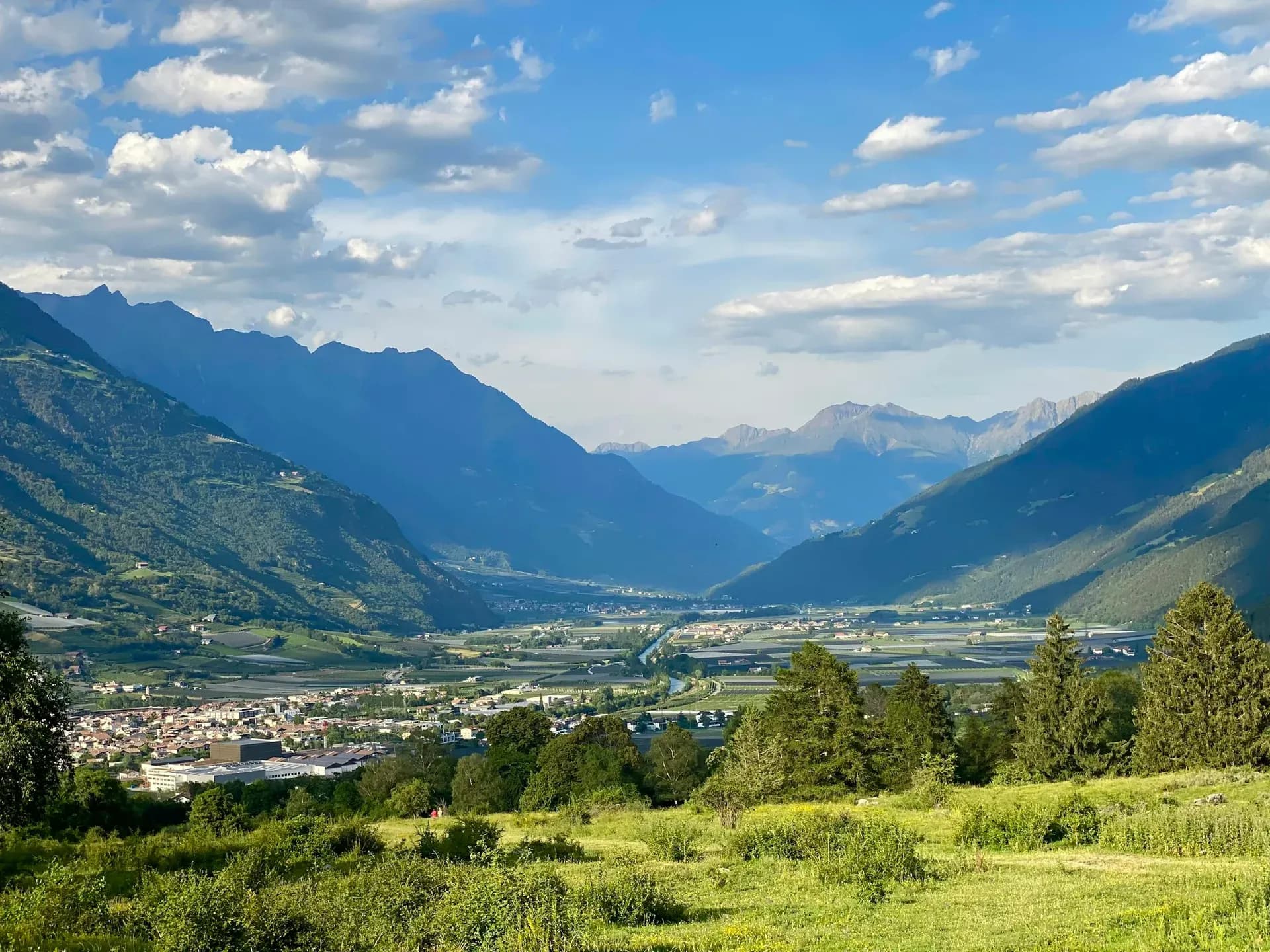 Blick über ein breites Alpental mit Dörfern und Bergen
